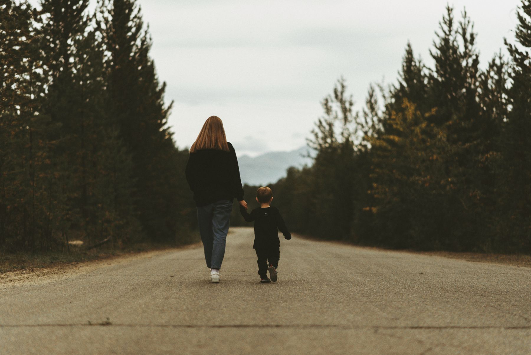 Parent holding a child's hand while walking together